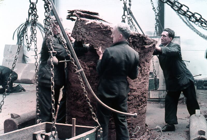 Dock workers check over a roll of tobacco. Photograph: Dublin Port Archive