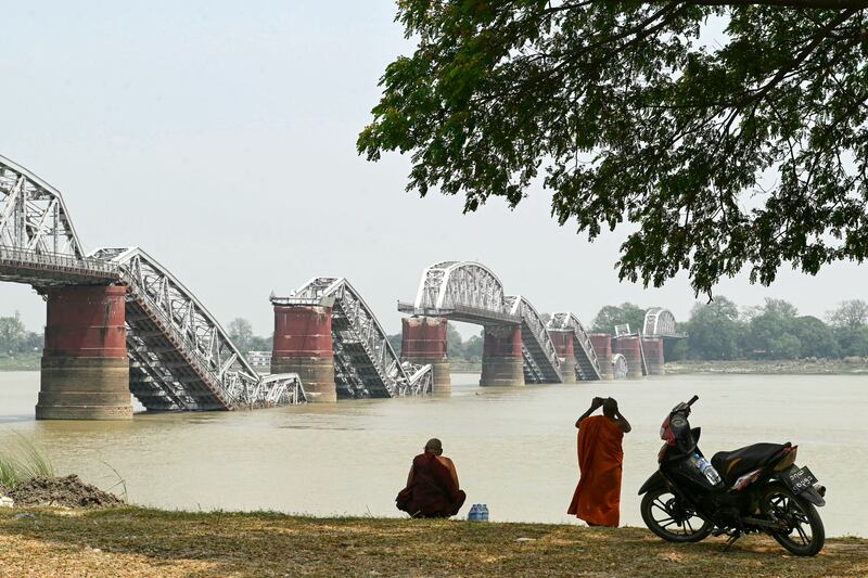 A monk takes photograph on the banks of the Irrawaddy River in front of the collapsed Ava Bridge, also known as the Inwa Bridge, in Sagaing, Myanmar. Photograph: Sai Aung Main/AFP via Getty Images         