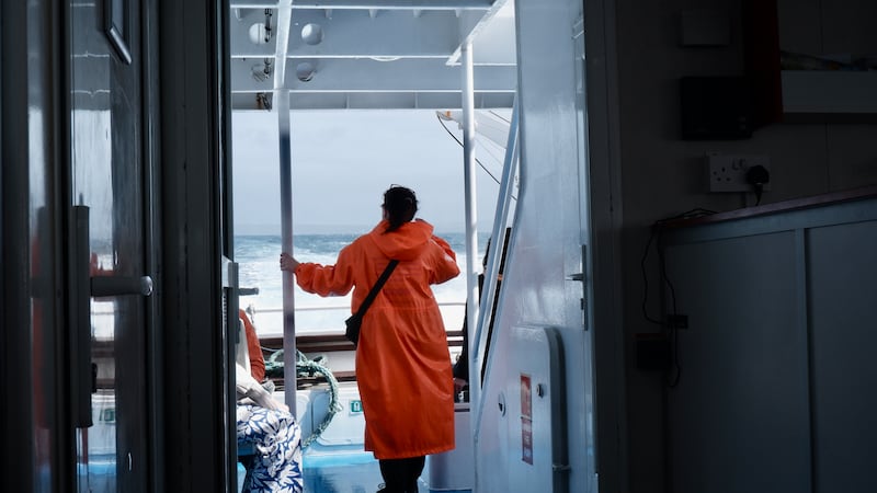 A tourist stands on the Doolin Ferry to Inis Meáin