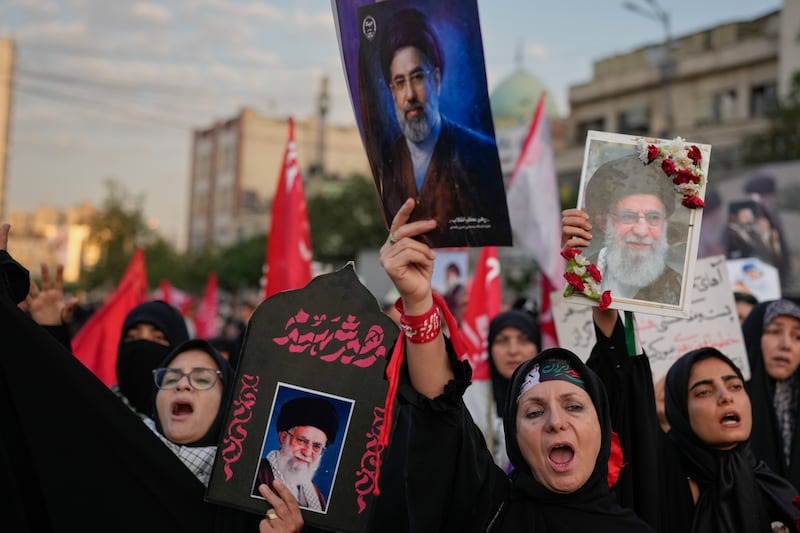 Mourners chant while holding portraits of Iran’s supreme leader Mojtaba Khamenei and Ayatollah Ali Khamenei during Khamenei’s funeral procession. Photograph: Altaf Qadri/AP
