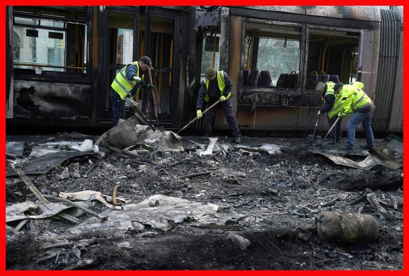 Debris is cleared from a burned out Luas and bus on O'Connell Street in Dublin. Photograph: Brian Lawless/PA Wire