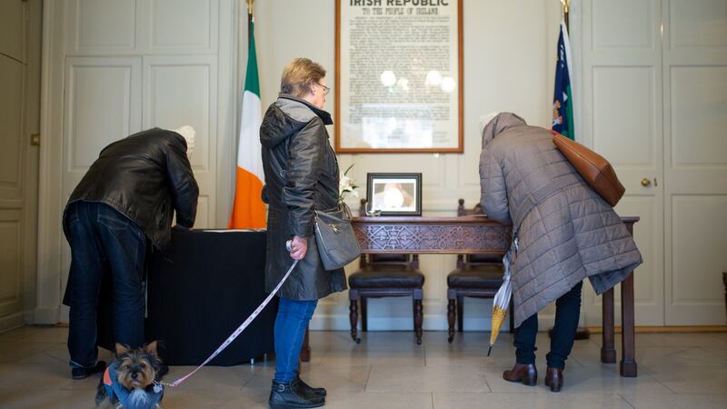 Helen Connolly, from Dublin, with her dog, waits to sign a book of condolence. Photograph: Tom Honan