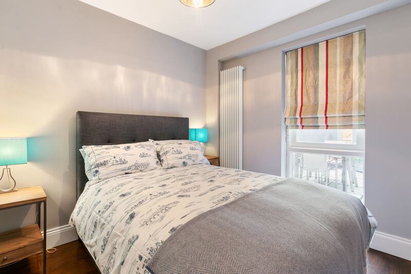 A double bedroom, currently used as a guest room, sits on the lower floor with a sash window looking on to the courtyard.