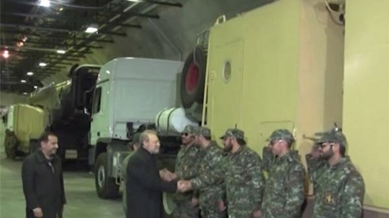 Iran’s parliament speaker Ali Larijani shakes hands with a soldier as he inaugurates a new underground missile depot in this undated handout photo released January 5th, 2016 by Farsnews.com.