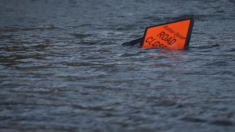 A ‘road closed’ sign is seen submerged in floodwater during Storm Ophelia in Galway. Photograph:  Clodagh Kilcoyne/Reuters