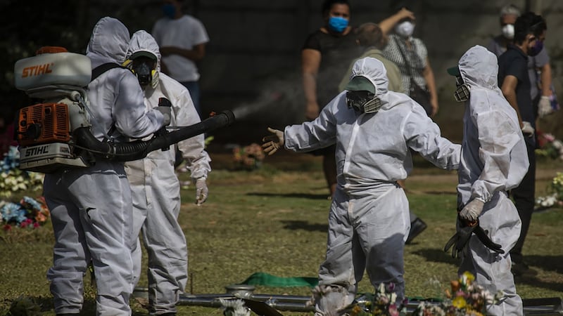 Gravediggers are disinfected after burying a body in Managua. Photograph: Inti Ocon/The New York Times