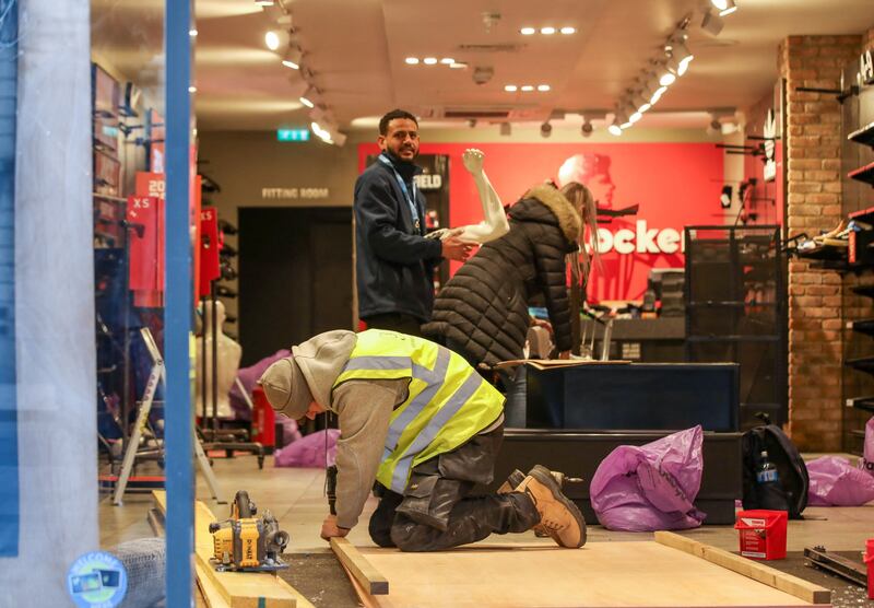 Workers clear up inside a Foot Locker shoe shop that was looted during the November 23 violent protests on O'Connell Street. Photograph: Paul Faith/AFP
