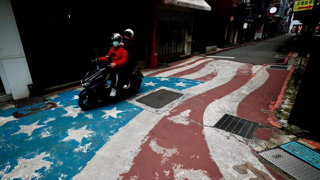 A Taiwanese motorist drives on an US flag painting at a street in Taipei. US President Joe Biden invited Taiwan to its ‘Summit for Democracy’ in December. Photograph: EPA/Richie E Tongo.