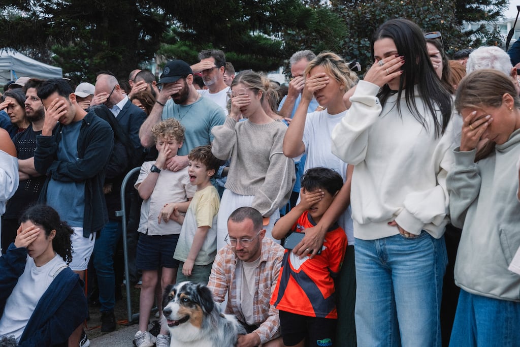 Mourners cover their faces during a moment of prayer at a tribute to those killed in the shooting attack at Bondi Beach in Sydney, Australia, on Monday. Photograph: Matthew Abbott/The New York Times