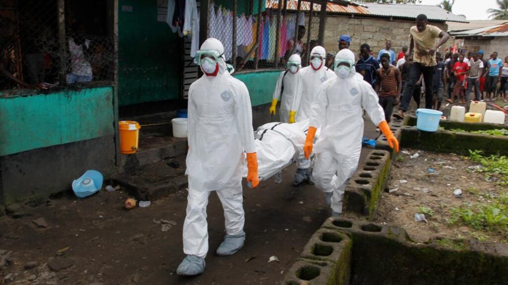 A Liberian burial squad carries the body of a suspected Ebola victim in the slum area of Logan Town outside Monrovia today. Photograph: Ahmed Jallanzo/EPA