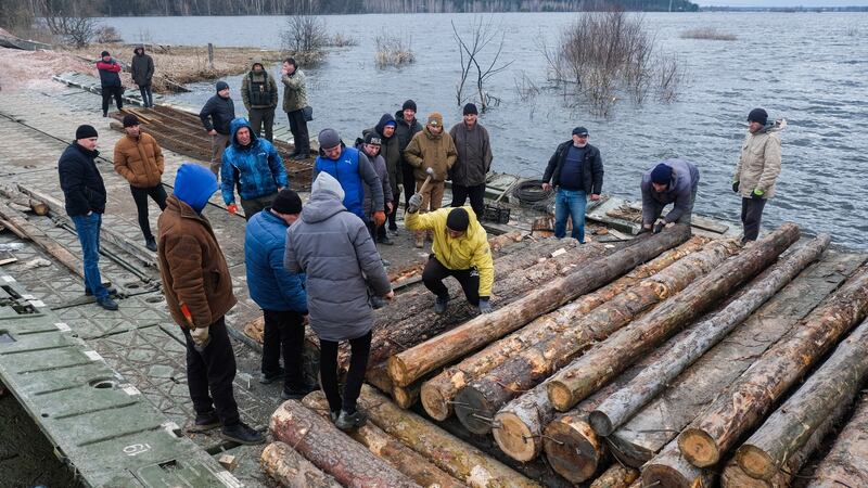 Soldiers and civilians repair a destroyed bridge over the Irpin river in Demydiv on the outskirts of Kyiv on April 6th. With the withdrawal of Russian troops from Kyiv’s villages, some civilians who left are returning home. Photograph:  Matthew Hatcher/SOPA Images/LightRocket via Getty Images