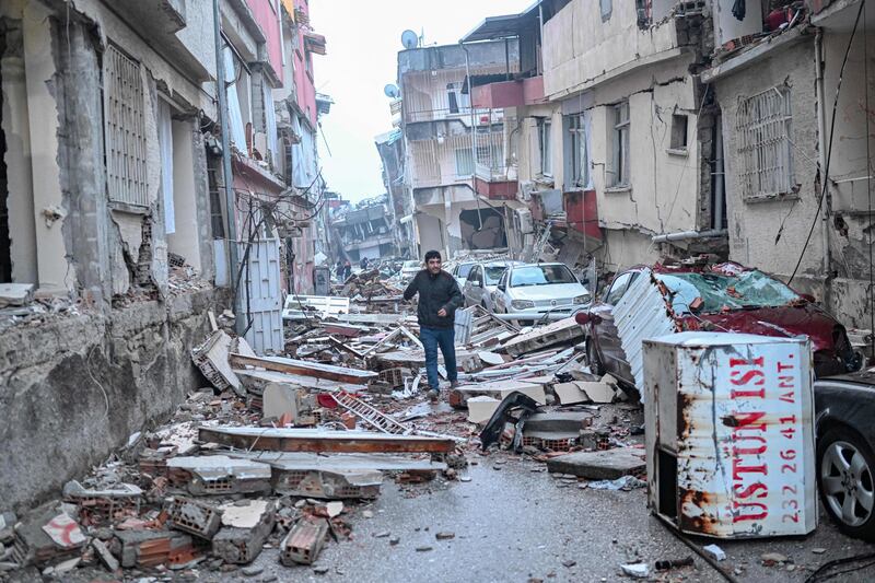 A man among the debris of collapsed buildings in Hatay, Turkey. Photograph: Bulent Kilic/AFP via Getty Images
