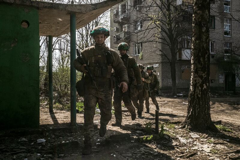 Ukrainian soldiers move between abandoned buildings in Bakhmut. Photograph: Mauricio Lima/New York Times
                      