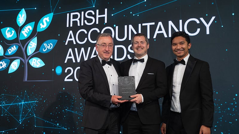 John Gaynor, awards judging coordinator, presents the finance team of the year award to Glenn Creighton and Arnold Maniaul, Arlo Technologies International