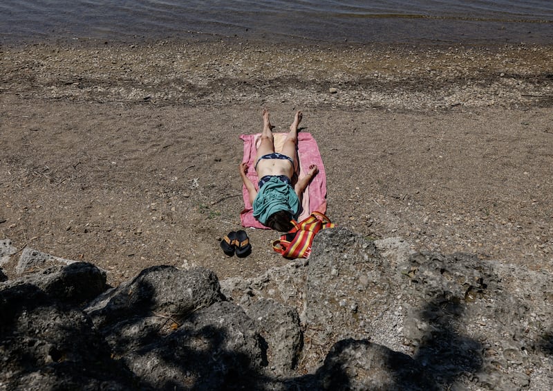 A woman sunbathes on the beach on the banks of the Bavarian lake Chiemsee in southern Germany amid this week's heatwave. Photograph: Michaela Stache/AFP via Getty Images          