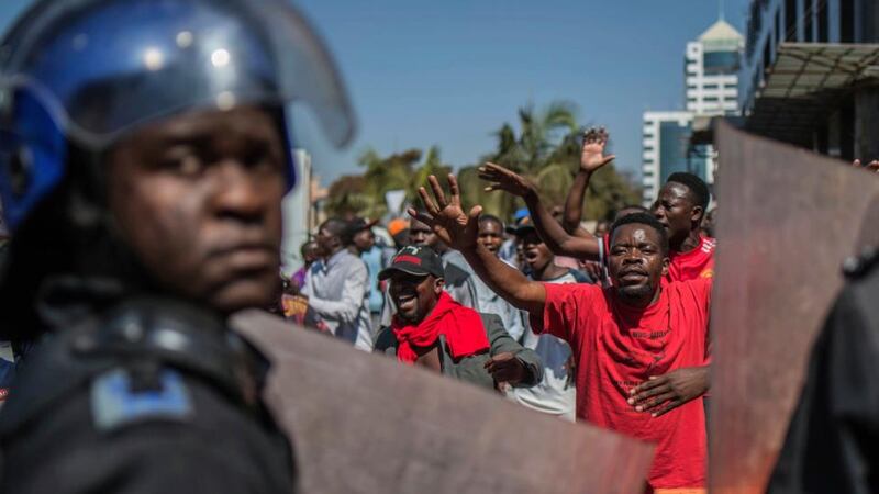 Police outside the Zimbabwe Electoral Commission offices as opposition supporters gather in Harare on  Wednesday. Photograph: Mujahid Safodien/AP
