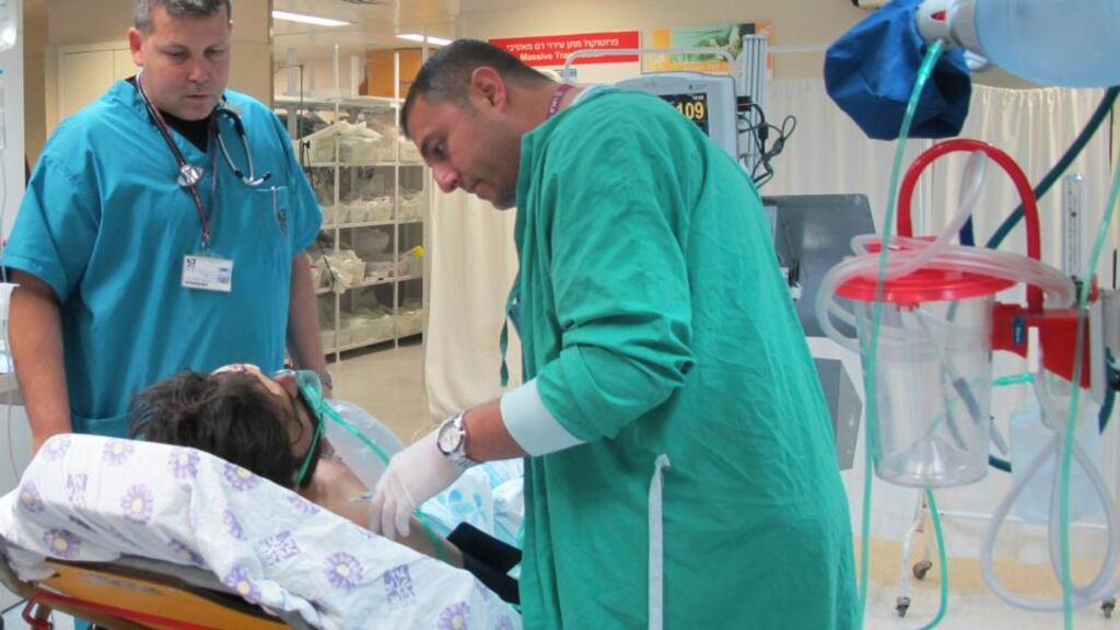 Israeli doctors stand at the bedside of a Syrian at Rambam Hospital in the northern Israeli city of Haifa. Israeli soldiers gave medical treatment today to four Syrians wounded in fighting near the ceasefire line on the Israeli-occupied Golan Heights, the army said. Photograph: Pioter Fliter/Rambam Hospital/Reuters
