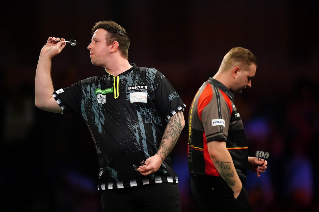Callan Rydz in action during his third round match against Dimitri Van den Bergh (right) at the World Darts Championship at Alexandra Palace, London. Photograph: Zac Goodwin/PA