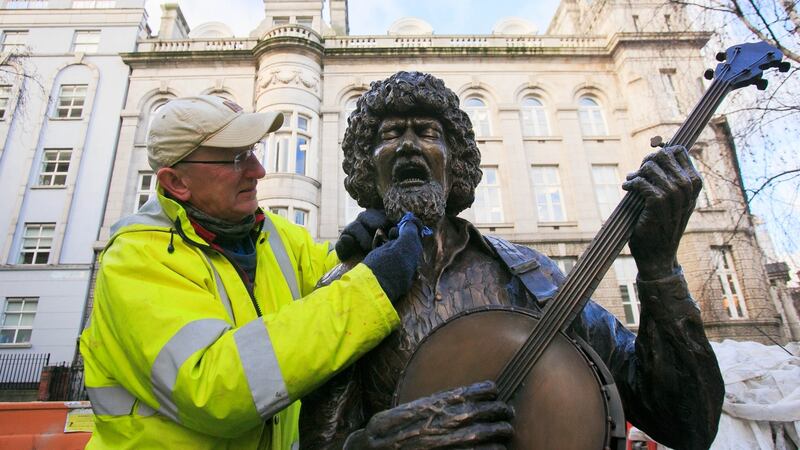 Sculptor John Coll who created the Luke Kelly Statue puts the finishing touches to the statue on South King Street, Dublin,  to mark the 35th anniversary of the death of the musician. Photograph: Gareth Chaney/Collins