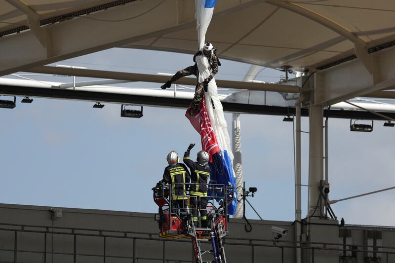 Firefighters work to rescue an air force parachutist whose canopy got jammed on the roof of the stadium prior to the Champions Cup game between Toulouse and Sale. Photograph: Valentine Chapuis/AFP via Getty
