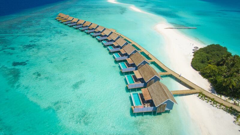 The luxury over  water villas, reached by a wooden walkway, at the Kuramathi resort in the Maldives.