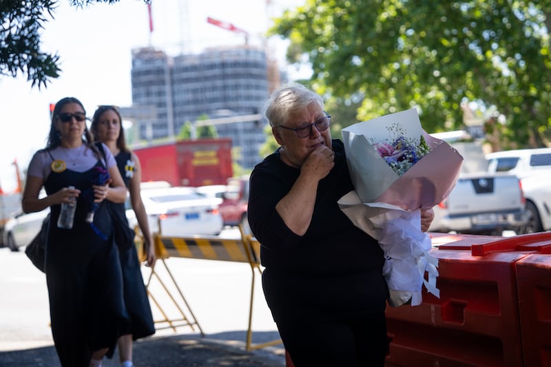 A woman carries flowers as people gather to attend the funeral service of Matilda, the youngest victim of the Bondi Beach mass shooting. Photograph: Audrey Richardson/Getty Images