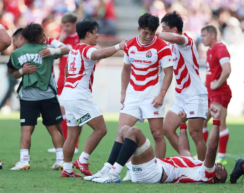 Japan players celebrate their victory against Wales. Photograph: STR/Jiji Press/AFP via Getty