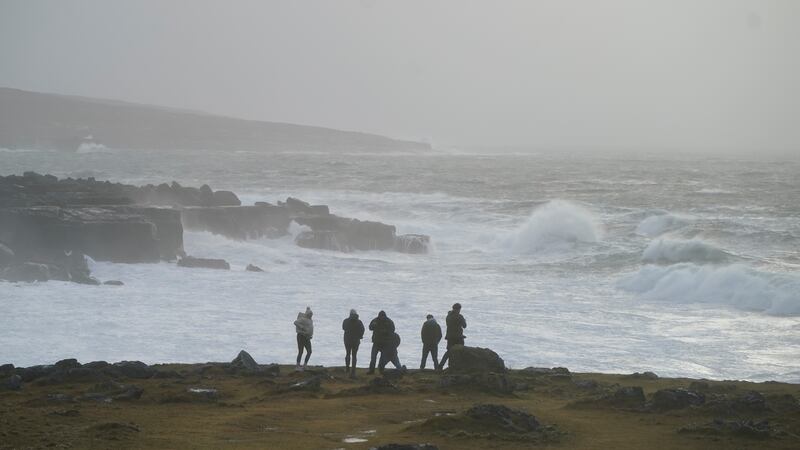 Tourists stand in the Burren, near Black Head lighthouse, in Co Clare in as Storm Jocelyn hits on Tuesday evening. Photograph: Niall Carson/PA Wire