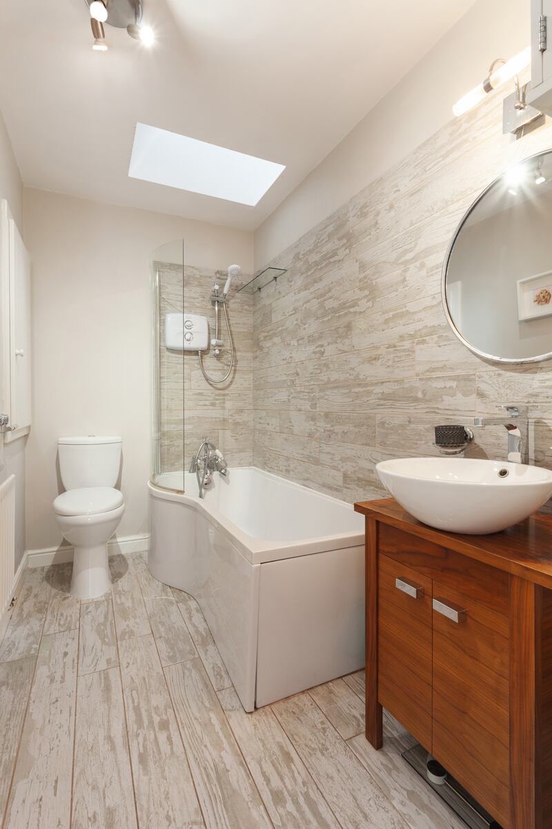 The bathroom has wood-effect tiling and a skylight.