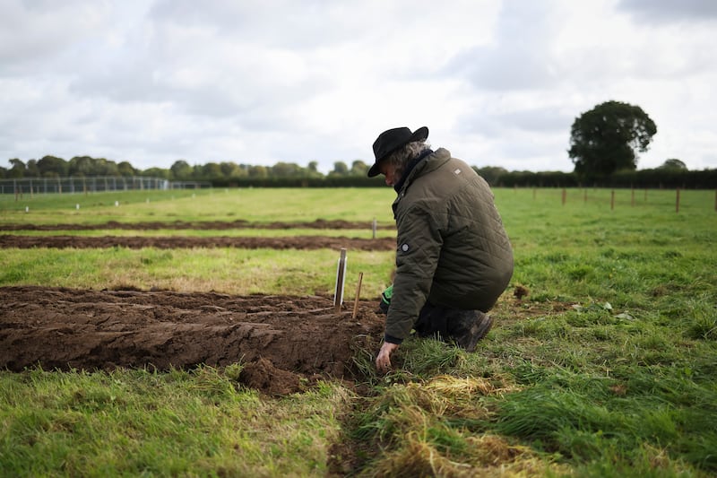 A competitor checks the soil at the horse drawn ploughing competition. Photograph:  Dan Dennison