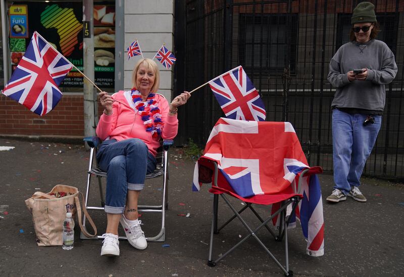 People gather on the street to watch an Orange Order parade in Belfast. 
Photograph: Brian Lawless/PA Wire