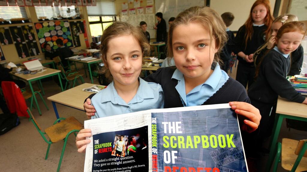 Twins Shayna and Orlaith Teggart, pupils at St Hugh’s National School in Dowra,  with a proof of the cover of The Scrapbook of Regrets. Photograph: Brian Farrell