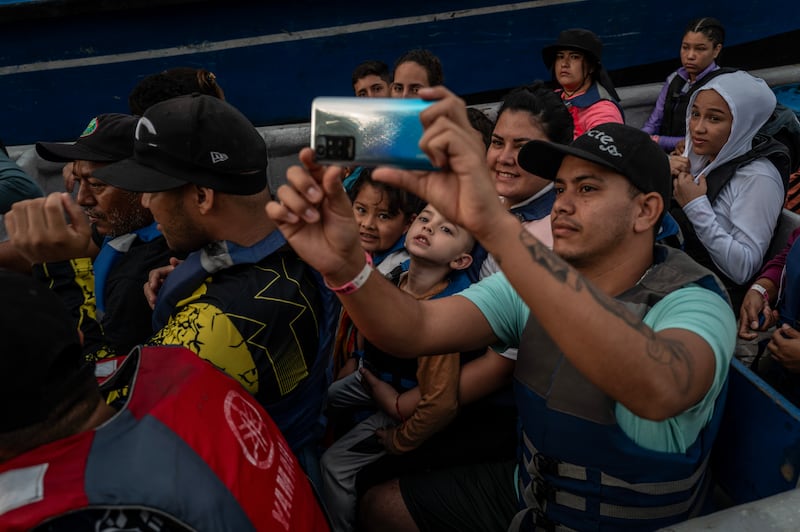 A fellow passenger takes a photo of Yessica Rojas and her children as they travel between Panama and Colombia by boat. Photograph: Federico Rios Escobar/New York Times