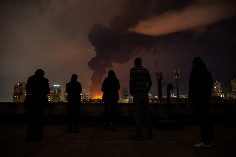 People in Tehran look on as smoke billows into the sky on Saturday night following a recent strike. Photograph: Arash Khamooshi/The New York Times