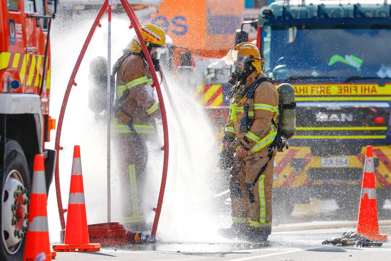  Firefighters rinse off after tackling a fire at  a four-storey hostel building in central Wellington, New Zealand. Photograph:  Hagen Hopkins/Getty Images