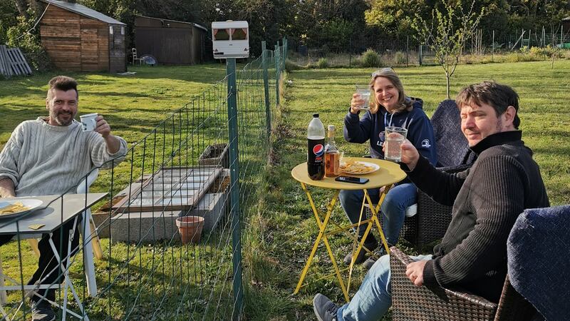Roisin Geber and her husband Sebastien enjoy a socially distanced drink with their neighbour Christophe in France
