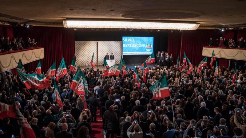 Forza Italia: supporters wave flags as Silvio Berlusconi arrives on stage. Photograph: Federico Bernini/Bloomberg