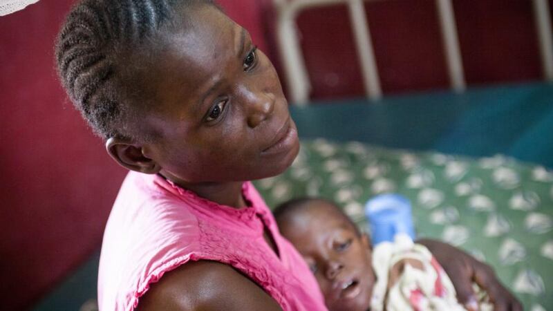 Suffering: Nina Yabingui, who is 30, cradles her three-year-old son, Dieu Fera. Photograph: Martti Penttilä