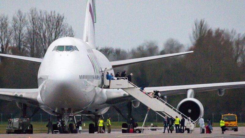 People wearing facemasks disembark from an aircraft repatriating British and other nationalities to the UK from Wuhan in China, following its arrival at a military base in  Oxfordshire. Photograph: Jacob King/PA Wire
