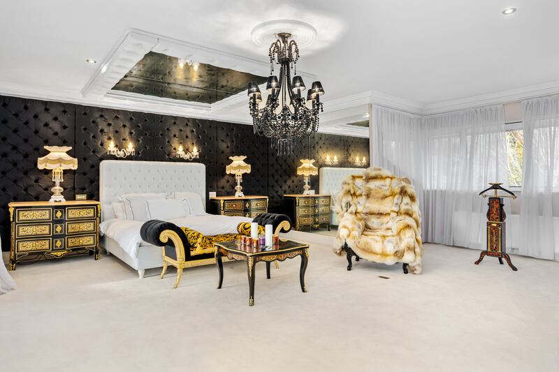 Principal bedroom with black leather studded wall and expanses of mirrors