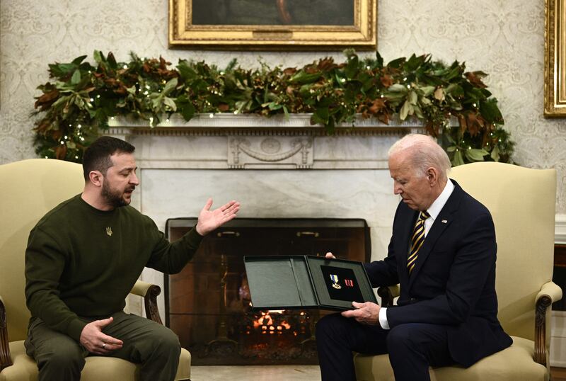 Ukraine's president Volodymyr Zelenskiy presents an award given to the captain of a unit in the Donbas medal to US president Joe Biden in the Oval Office  of the White House. Photograph:  Brendan Smialowski/AFP via Getty Images