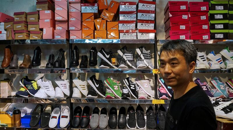A Chinese salesman sells copies of various American footwear brands inside a shopping complex in Shanghai. Beijing has warned it “will not sit idle” if a US probe into its intellectual property practices leads to sanctions. Photograph: Chandan Khanna/AFP/Getty Images