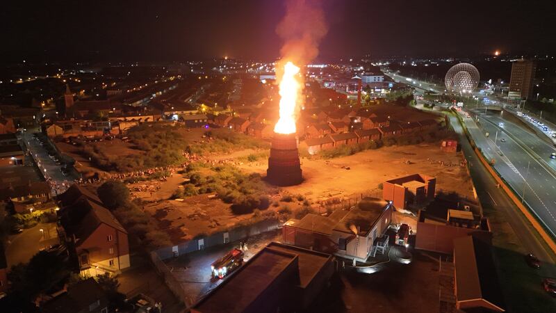 Firefighters work to protect an electricity sub station as a bonfire burns at Meridi Street, off the Donegall Road in Belfast. Photograph: Niall Carson/PA Wire