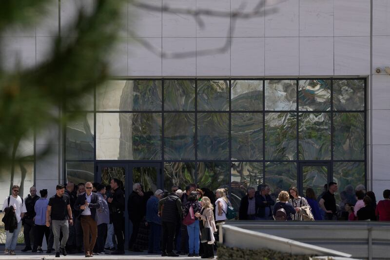 People gather outside a court building in Athens after a gunman opened fire. Photograph: Petros Giannakouris/AP