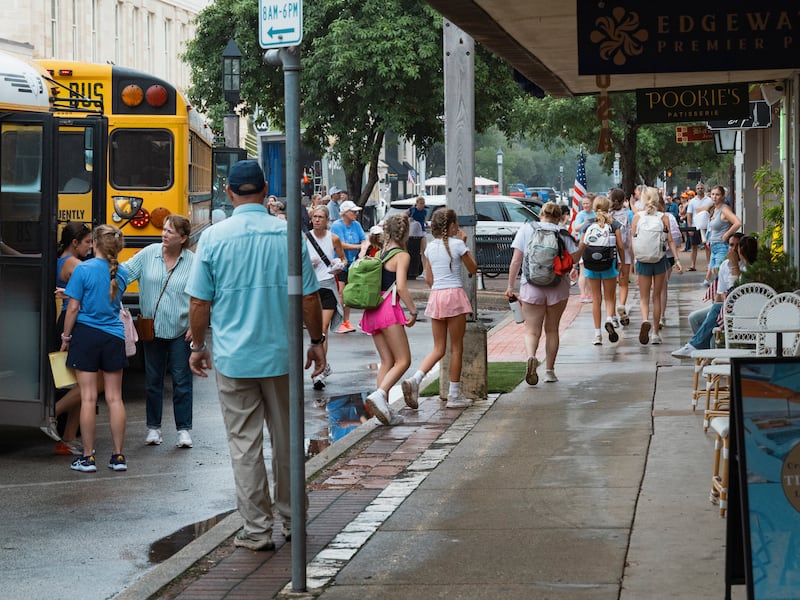 Buses carrying girls who were at Camp Waldemar unload in downtown Kerrville, Texas to reunite with family. Photograph: Jordan Vonderhaar/The New York Times