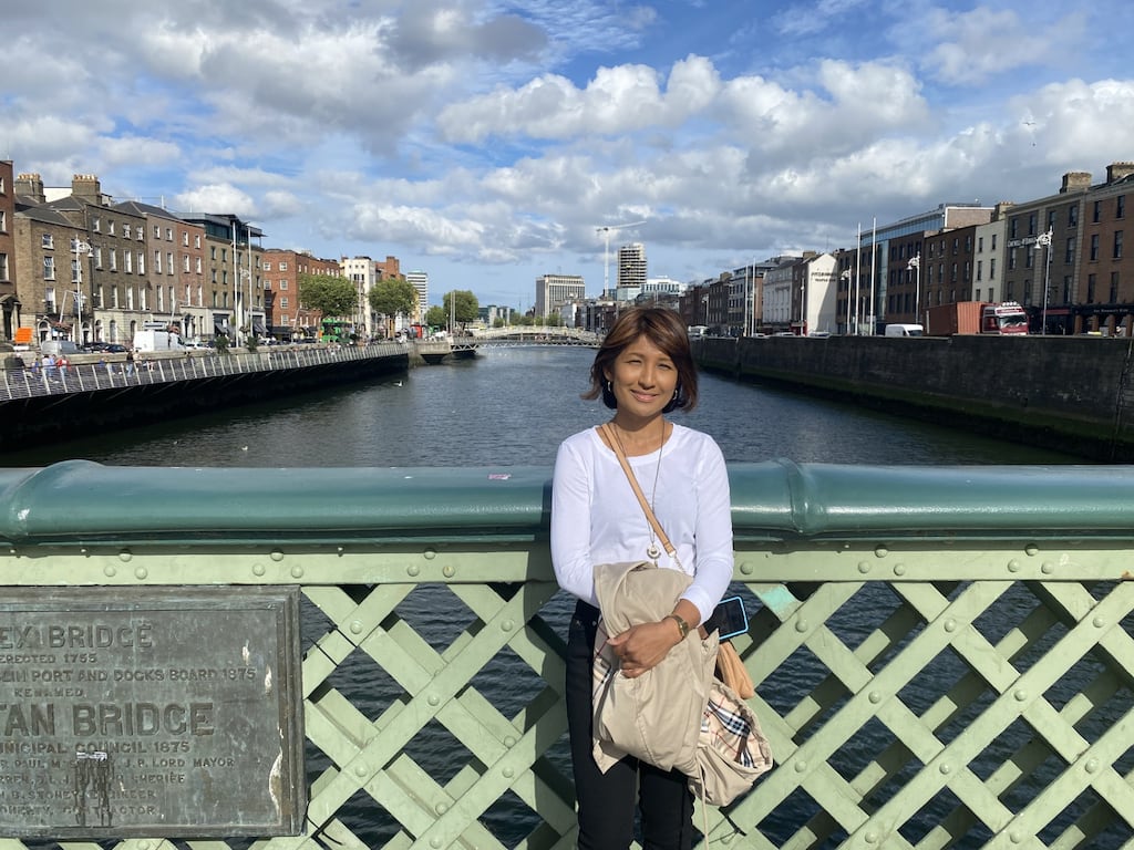 Usha Flores, visiting Ireland from Michigan, standing on Grattan Bridge in Dublin