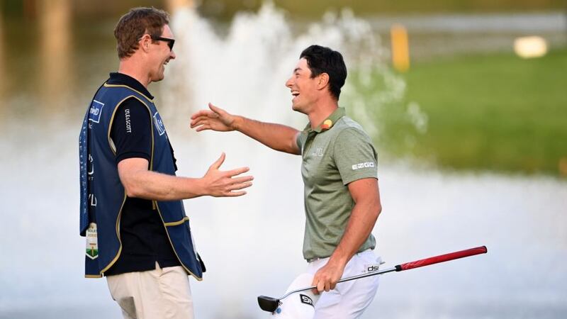Viktor Hovland of Norway is congratulated by his caddie after winning at the first playoff hole at the  Dubai Desert Classic. Photograph: Ross Kinnaird/Getty Images