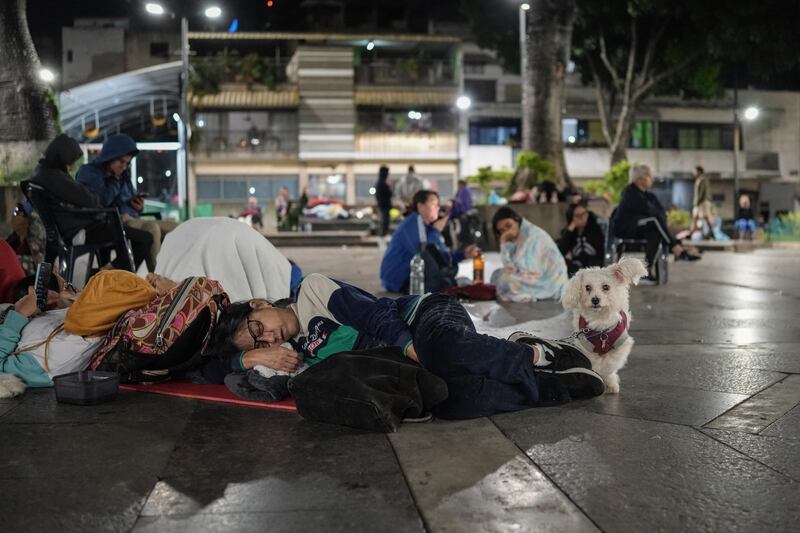 A woman sleeps next to her dog in a square following an earthquake in Caracas on June 25, 2026. Photograph: Manaure Quintero / AFP via Getty Images