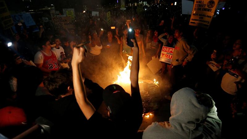 A Donald Trump pinata is burned by protesters in downtown Los Angeles. Photograph: Mario Anzuoni/Reuters