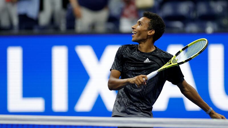 Felix Auger-Aliassime of Canada hits tennis balls to the crowd after winning against Carlos Alcaraz of Spain due to Alcaraz retiring early in the second set of their quarter-final. Photograph:  Sarah Stier/Getty Images